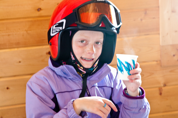 Emma enjoys quick hot cider before snowmobiling in Routt National Forest